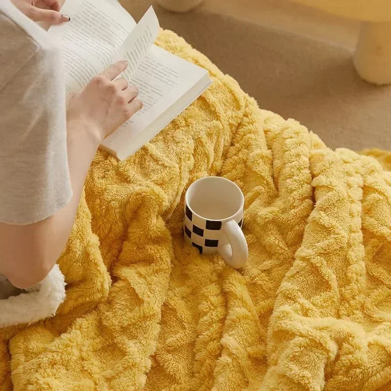 Winterdeken geel met reliëfmotief op bed
