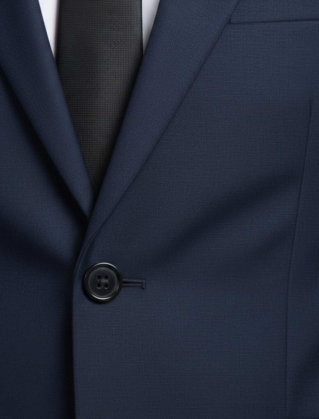Detail van de reverskraag en knoop van het kostuum in Marineblauw