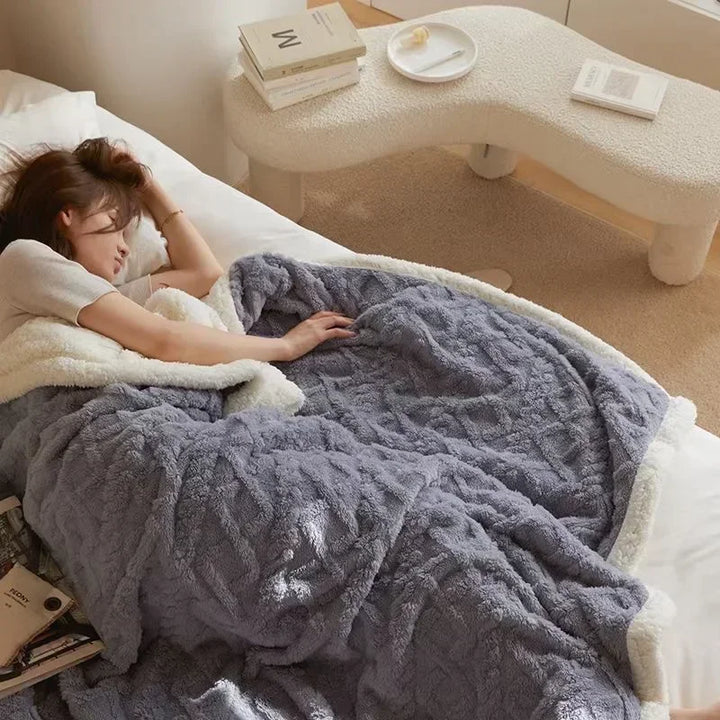Winterdeken grijsblauw met reliëfmotief op bed