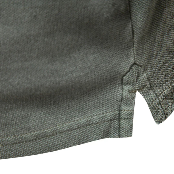 Detail van de zijsplit en de katoenen structuur van het poloshirt
