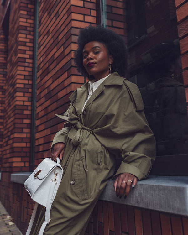 Vrouw in kaki trenchcoat