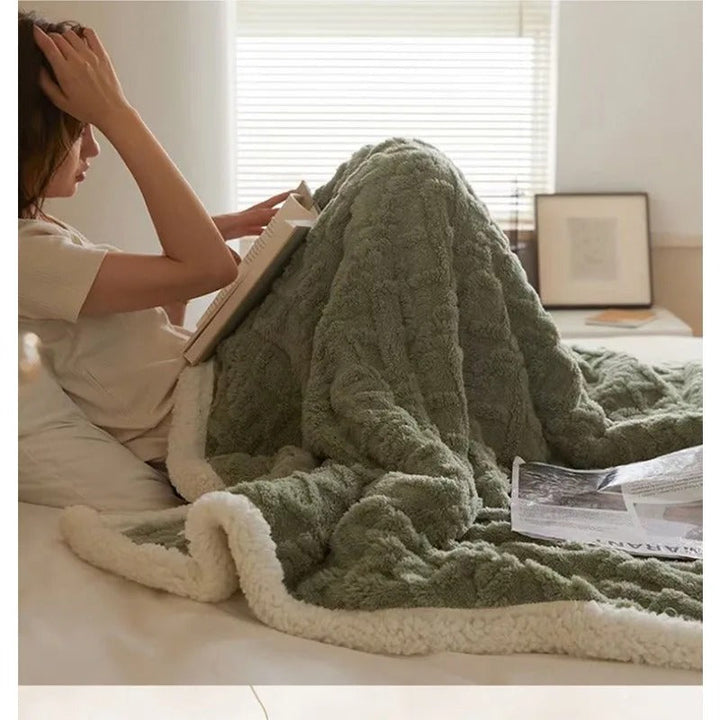 Saliegroene winterdeken over schoot op bed
